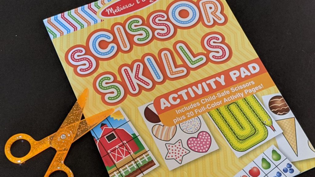 photo of a scissors skills book and a pair of scissors, which are wonderful craft supplies for toddlers just learning how to cut