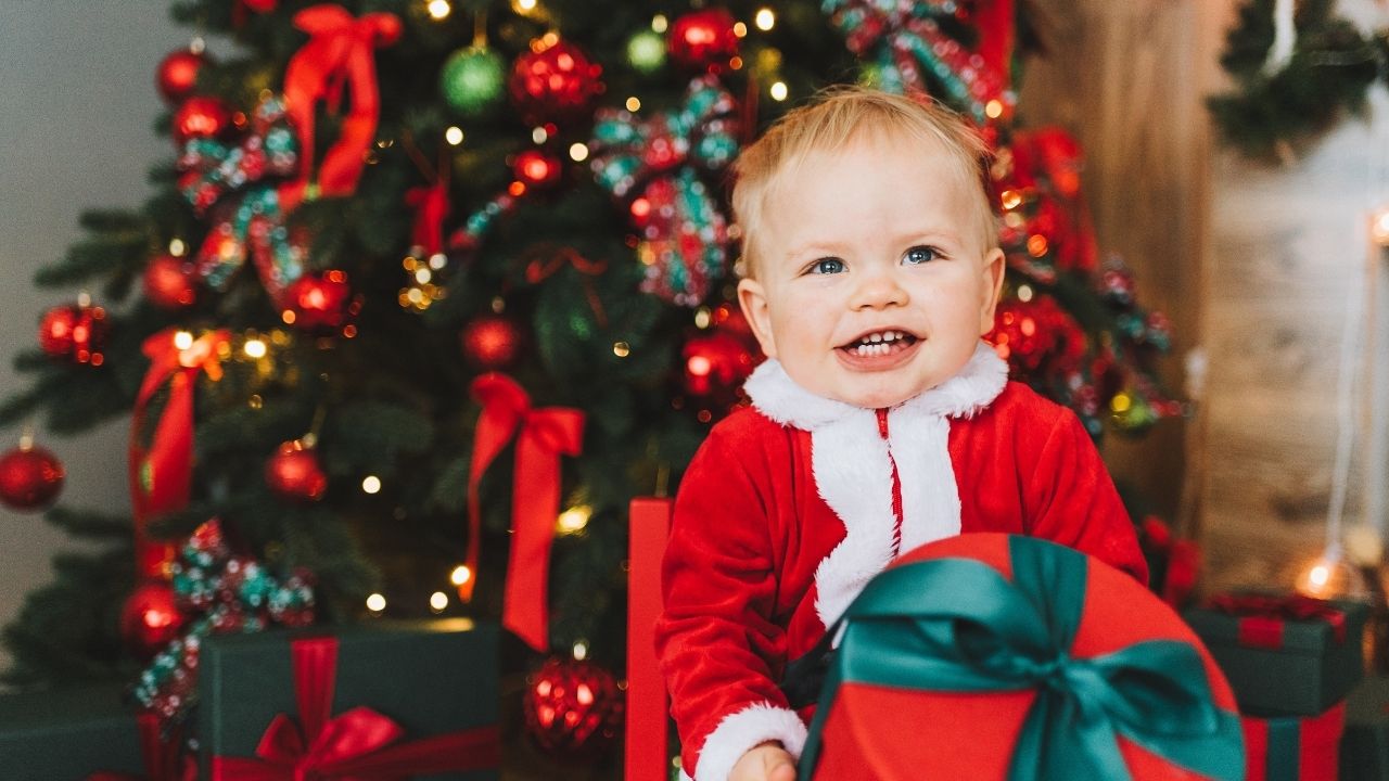 one year old holding a christmas eve box