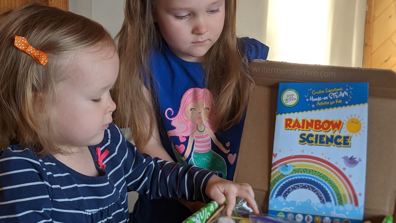 my girls looking at their rainbow science craft box