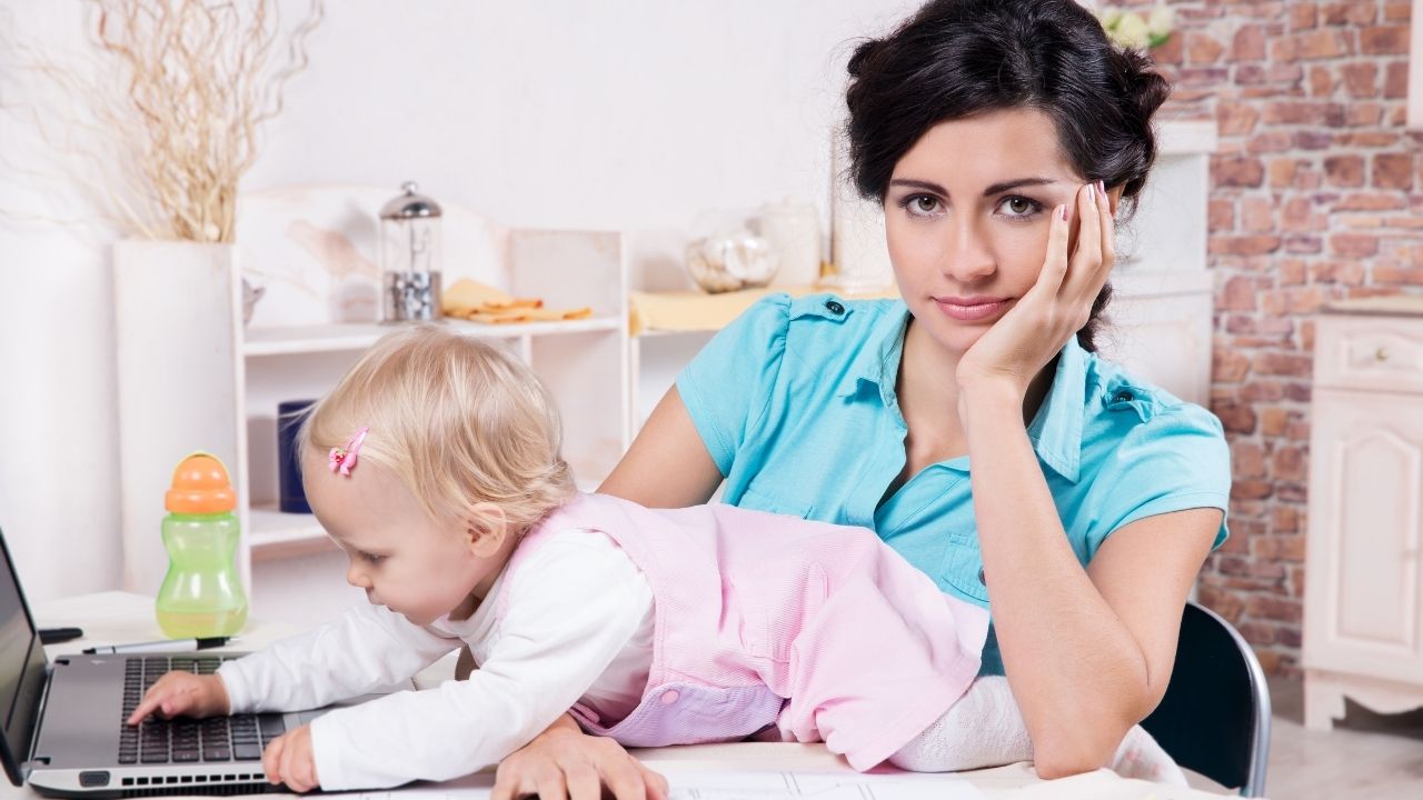 a mom and her baby in front of a laptop - the featured image for the article on gadgets to make busy mom's life easier